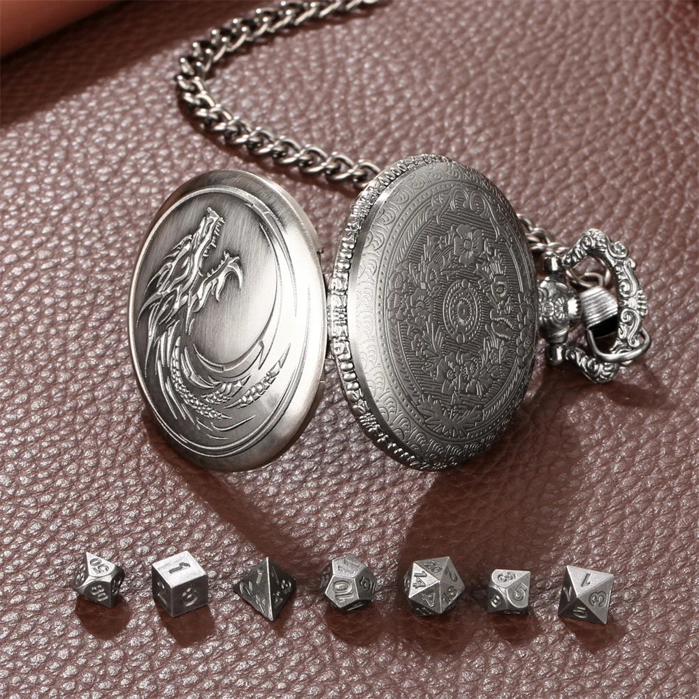 A silver steampunk dragon pocket watch and dice case with seven small dice resting on a brown textured surface.