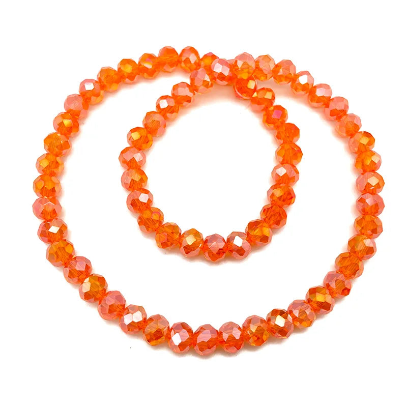 A strand of bright orange faceted crystal beads used for jewelry making.