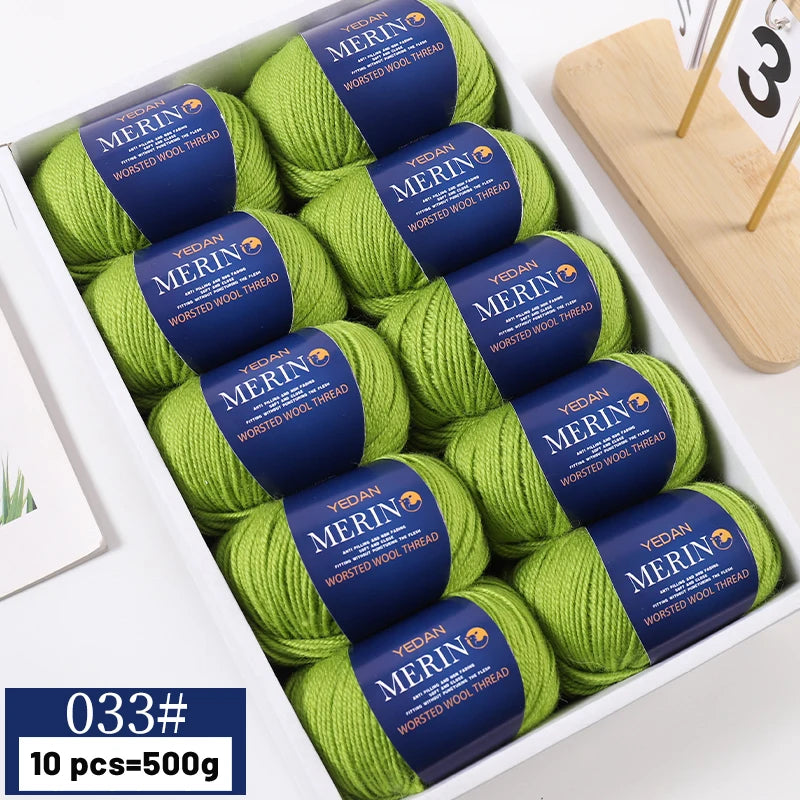 A box of ten balls of green merino wool yarn for knitting projects
