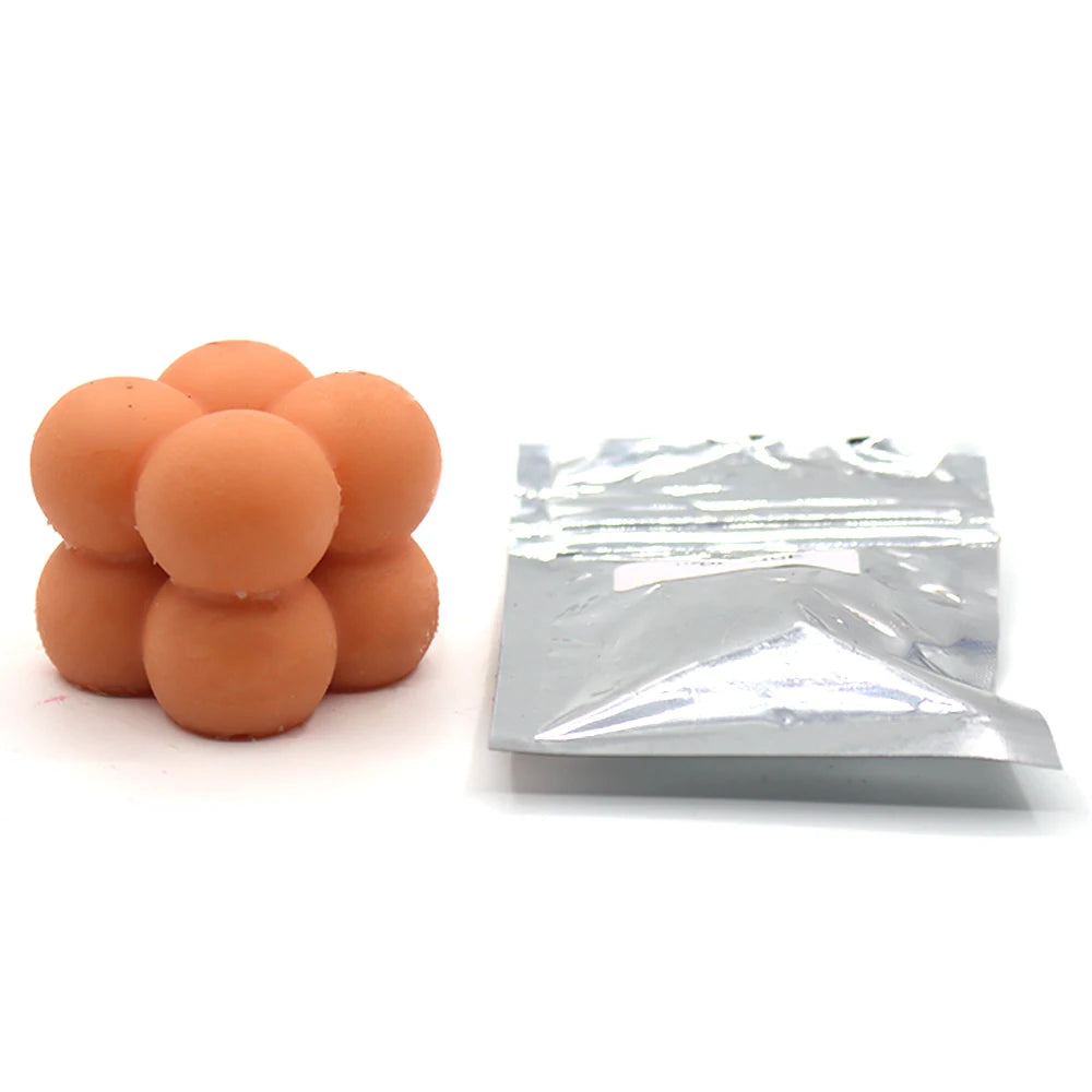 A pile of orange candle dye chips for soy wax, beeswax, and paraffin.