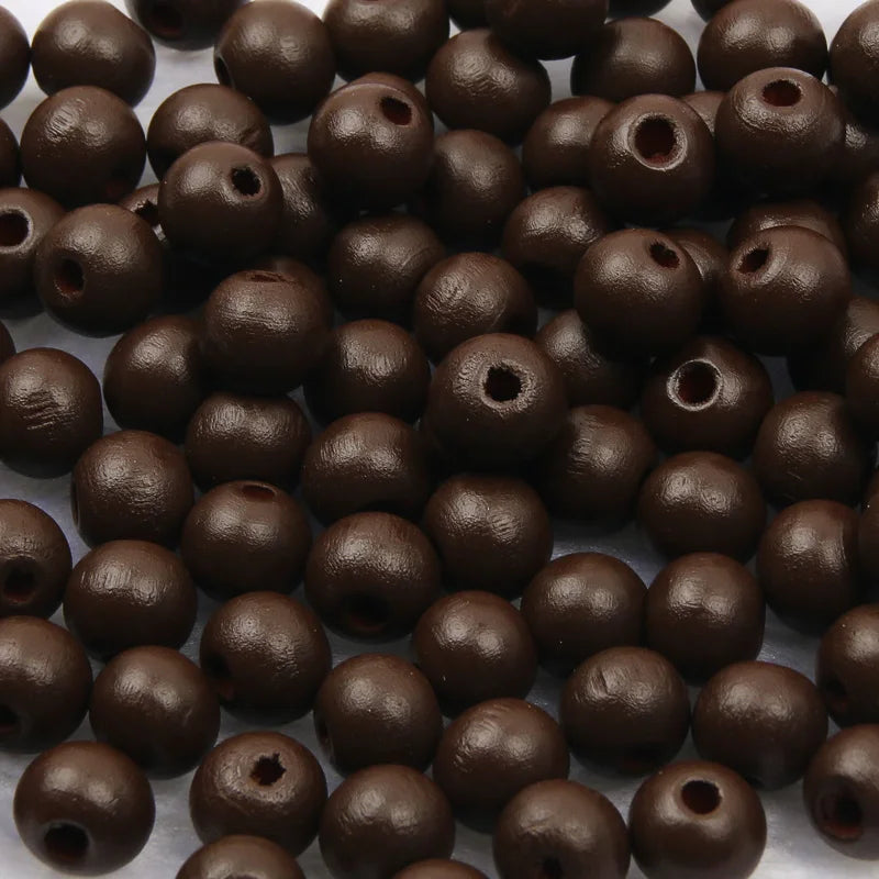A pile of dark brown natural wooden beads for jewelry making and DIY crafts