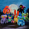 A collection of colorful monster plush dolls with big teeth against a bright moon background.