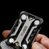 A hand holds a black metal magnetic fidget slider device against a gray textured background.