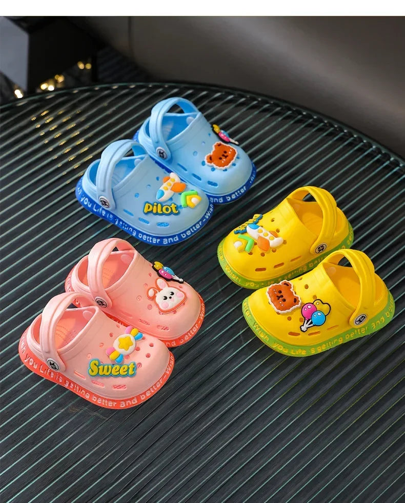 A collection of colorful children's plastic clogs in blue, yellow, and pink resting on a dark surface.