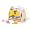 A wooden hand bell for sensory play featuring yellow and pink colored blocks.