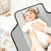 A baby is lying on a portable foldable waterproof diaper changing pad with a white headband, demonstrating easy storage.