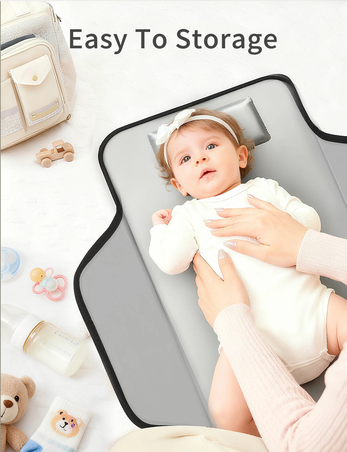 A baby is lying on a portable foldable waterproof diaper changing pad with a white headband, demonstrating easy storage.