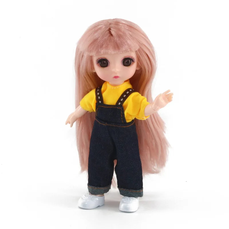 A 16cm articulated BJD princess doll with long pink hair wearing a yellow shirt and dark overalls.