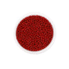 A clear plastic container filled with small, round, red glass seed beads for jewelry making.