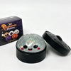 A black tin box and a clear Halloween-themed squishy stress relief toy are shown on a white background.