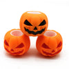 An orange Halloween pumpkin squishy fidget toy with a carved face is shown against a white background.