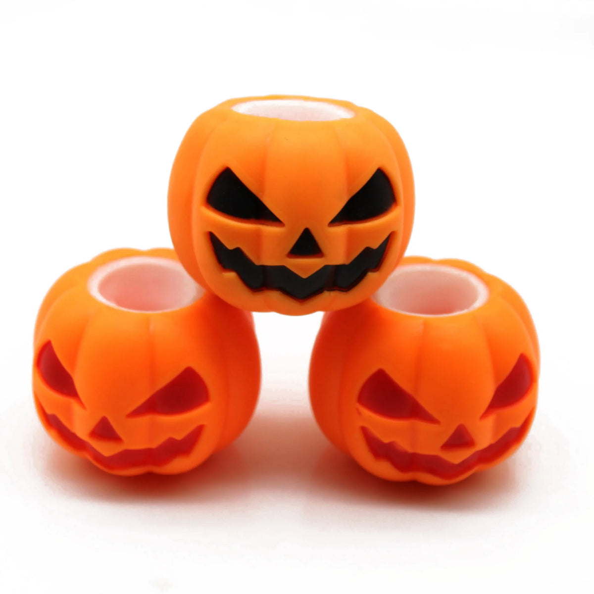 An orange Halloween pumpkin squishy fidget toy with a carved face is shown against a white background.