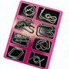 A pink plastic tray holding eight small metal brain teaser puzzle pieces.