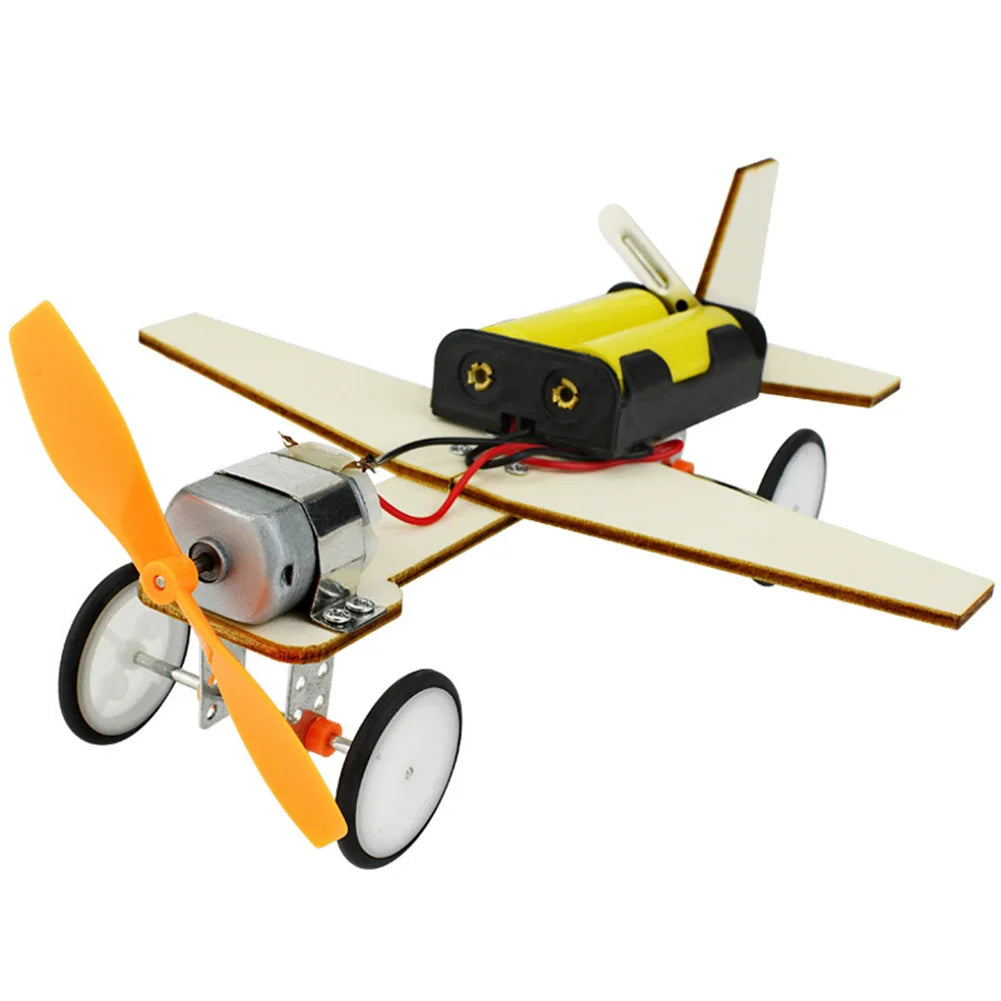 A wooden paddle boat kit with a yellow hull, black motor, and orange propeller.