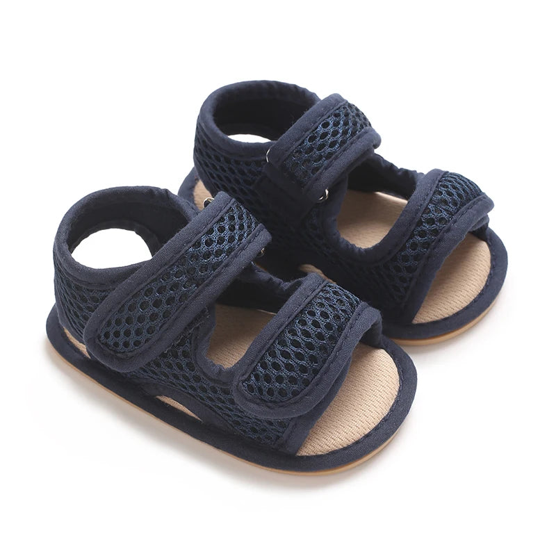 Pair of navy blue breathable first walker sandals for baby with hook-and-loop closure and soft sole