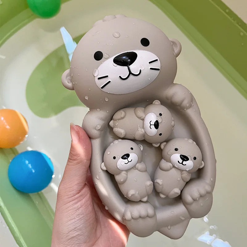 Una mano sostiene un molde de silicona gris de un oso con tres figuras de osos más pequeños, usado para juguetes de baño inte