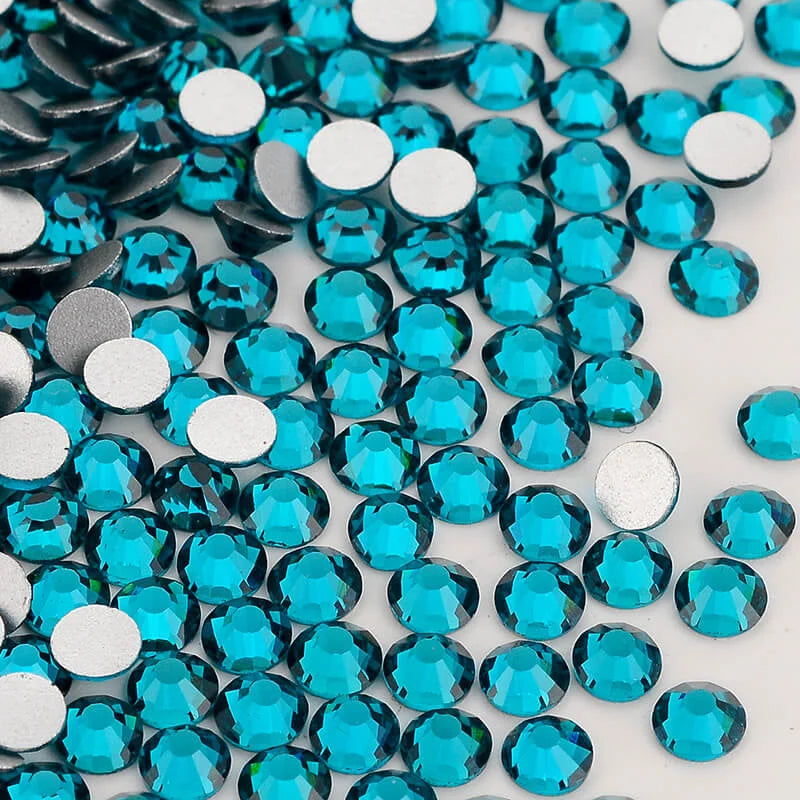 A close-up view of various round, faceted blue and silver glass crystal rhinestones.