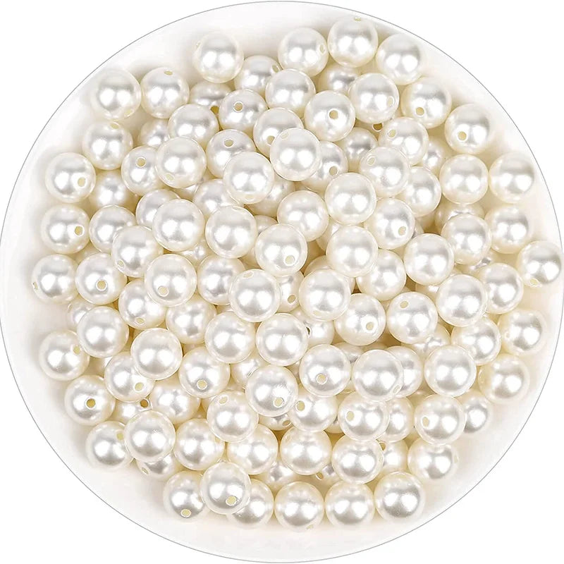 A pile of small, round ivory pearl beads for DIY jewelry making.