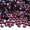 Dark purple and black glass crystal rhinestones scattered on a white background