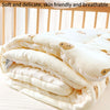 A stack of soft, white fleece blankets with light brown bear designs is folded on a white surface.