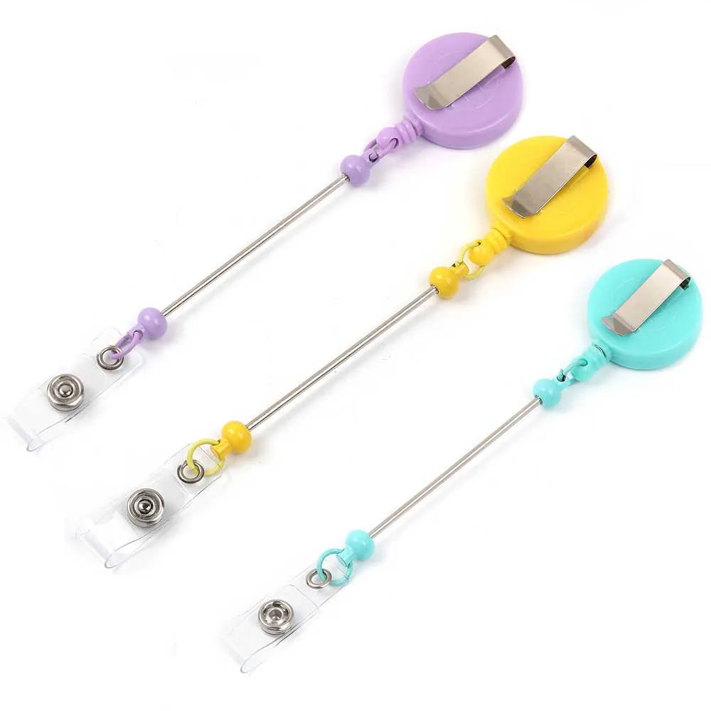 A set of purple and yellow beadable badge reels with retractable clips for DIY decorative ID holders.