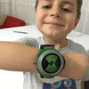 A young boy is holding a green and black watch toy, the Ben 10 Omnitrix Projector Watch Toy, in front of him.