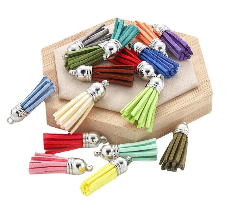 A collection of mixed color velvet tassels in various shades are displayed on a wooden surface.