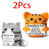 Two handmade crochet cat figurines, one gray and one orange, with positive affirmations written on them.