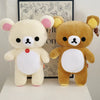 A plush toy of Rilakkuma in a strawberry bear design with light yellow fur and pink accents.