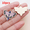 Ten gold-toned butterfly drop charms are displayed on a hand, showing the detailed design and texture.