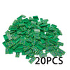 A pile of green building blocks shaped like coins, intended for a treasure chest set.