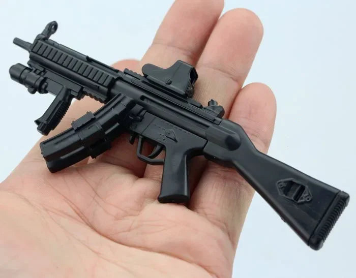 A black 1:6 scale MP5SD5 submachine gun model kit being held in a person's hand.