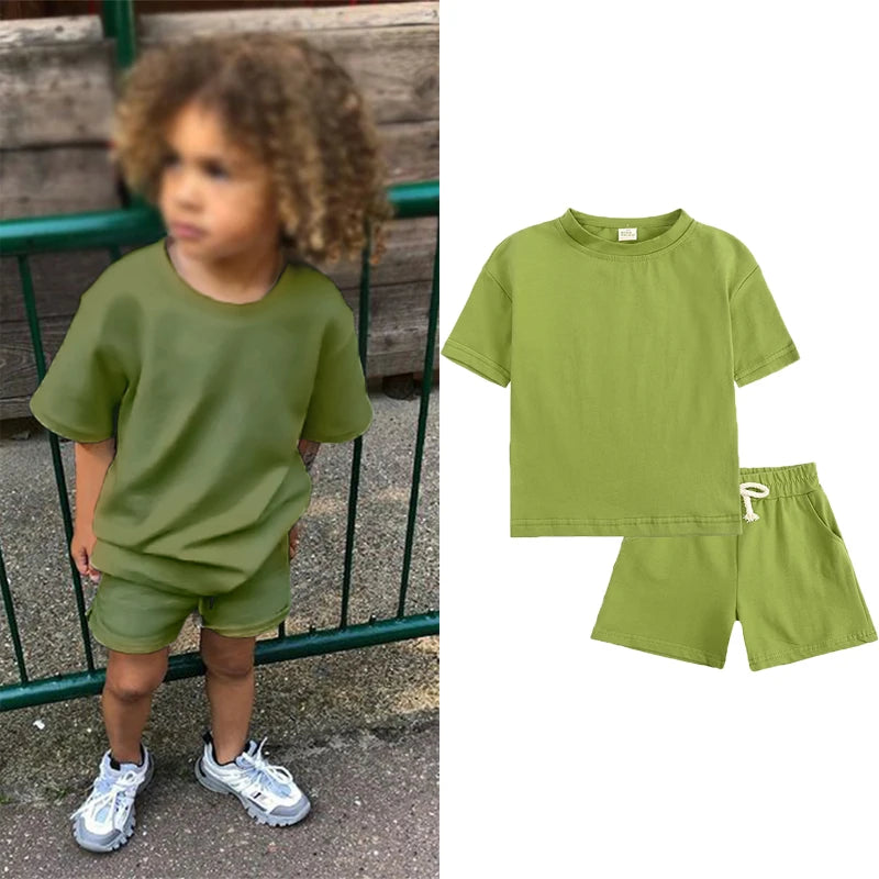 A child models a lime green short sleeve top and matching shorts set.