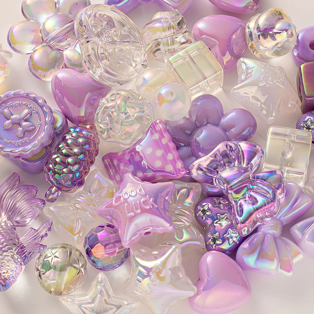 A collection of iridescent purple and clear acrylic bow and flower beads for DIY jewelry making