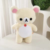 A soft, cream-colored Rilakkuma anime plush bear with pink accents sitting on a white surface.