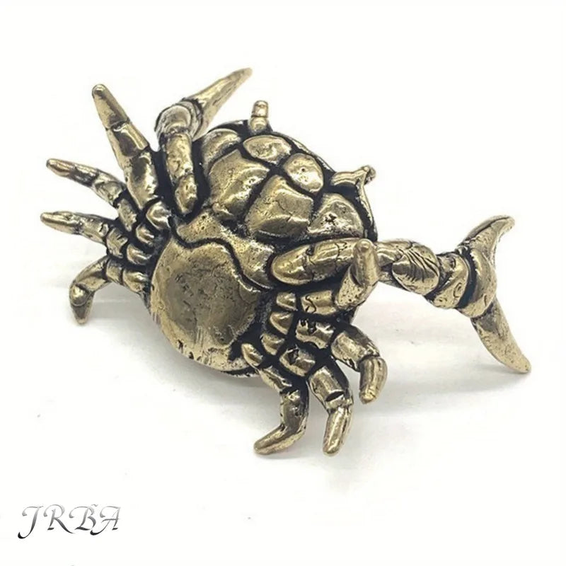 A brass figurine of a crab, resembling an animal desk statue.