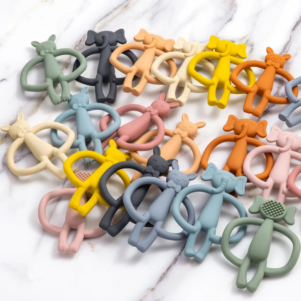 A collection of silicone teething toys in various pastel and earthy colors, including yellow, orange, pink, green, and gray.