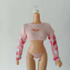 A pink knitted doll fashion set featuring a cropped top and long sleeves with pink and white floral patterns.