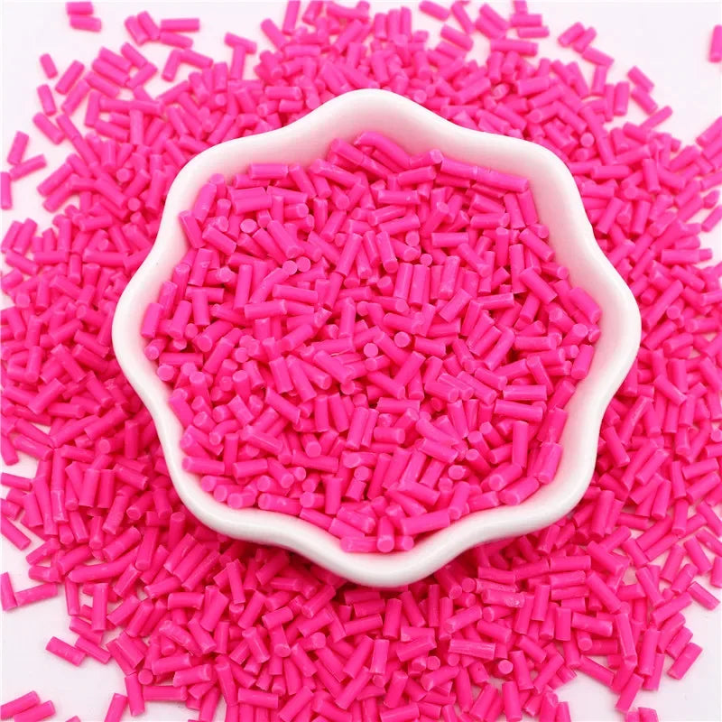 Pink polymer clay slice sprinkles in a white dish scattered on a pink background