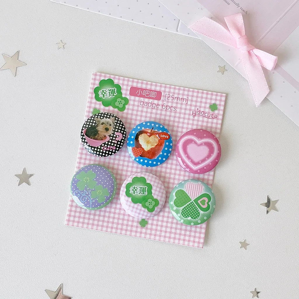 A set of six pink and green kawaii mini pin badges featuring animals and floral designs on a pink paper.