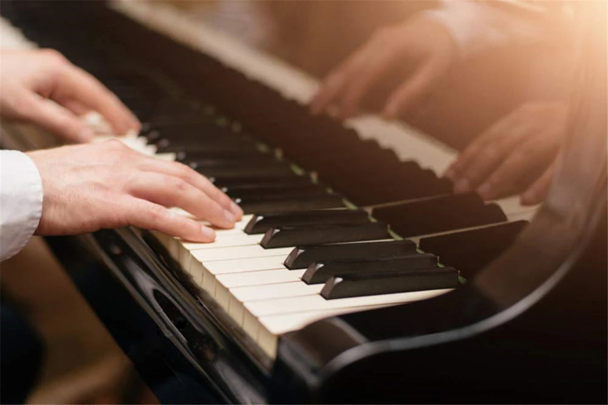 Hands playing a piano keyboard with note stickers on white and black keys.