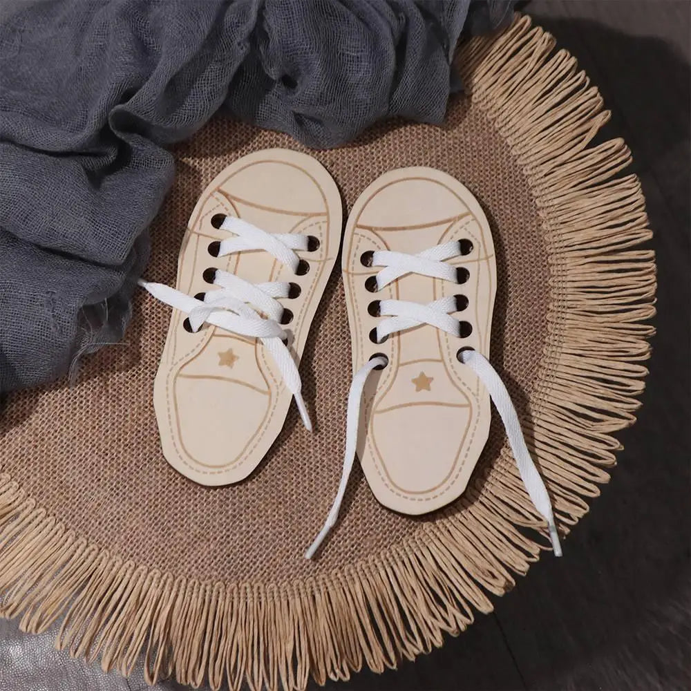 A pair of light tan wooden lacing shoes resting on a woven mat with fringe, next to a gray cloth.