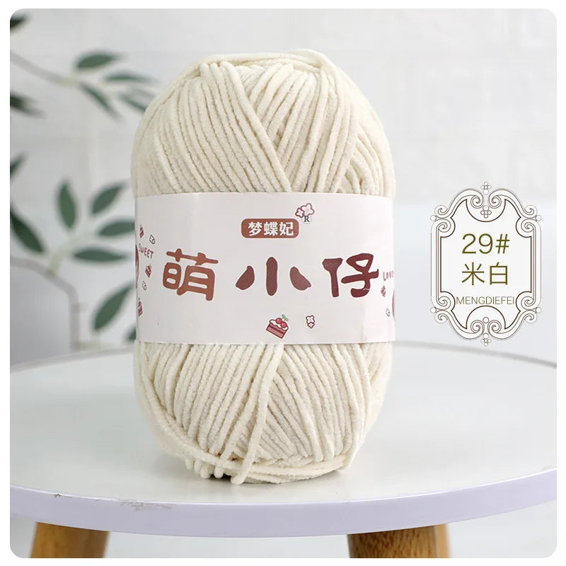 A ball of cream-colored chenille yarn labeled with Chinese characters for knitting and crochet.