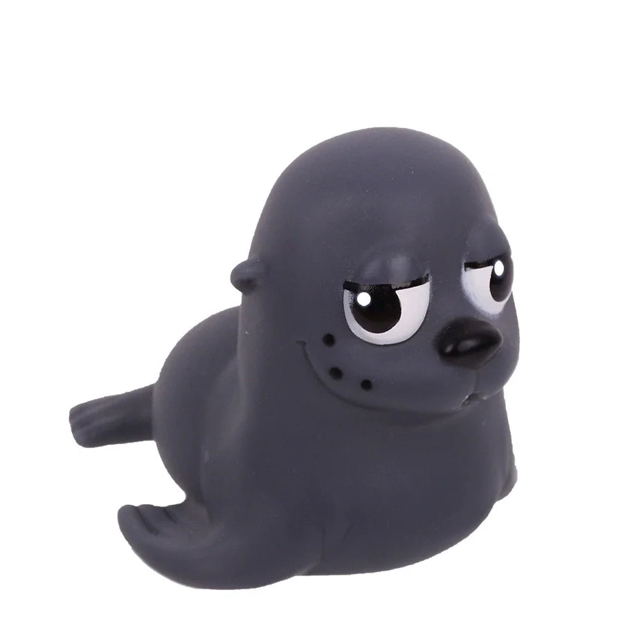 A dark gray rubber toy of a seal or sea creature with large eyes and a smooth body.