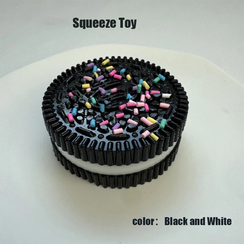 A black and white squeeze toy cake decorated with colorful sprinkles on a white plate.