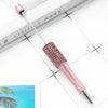A pink beaded ballpoint pen craft kit with a silver needle is displayed on a white surface next to a book.