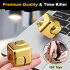 Un cube tournant en alliage d'or, jouet anti-stress, sur un ordinateur portable et dans une main.
