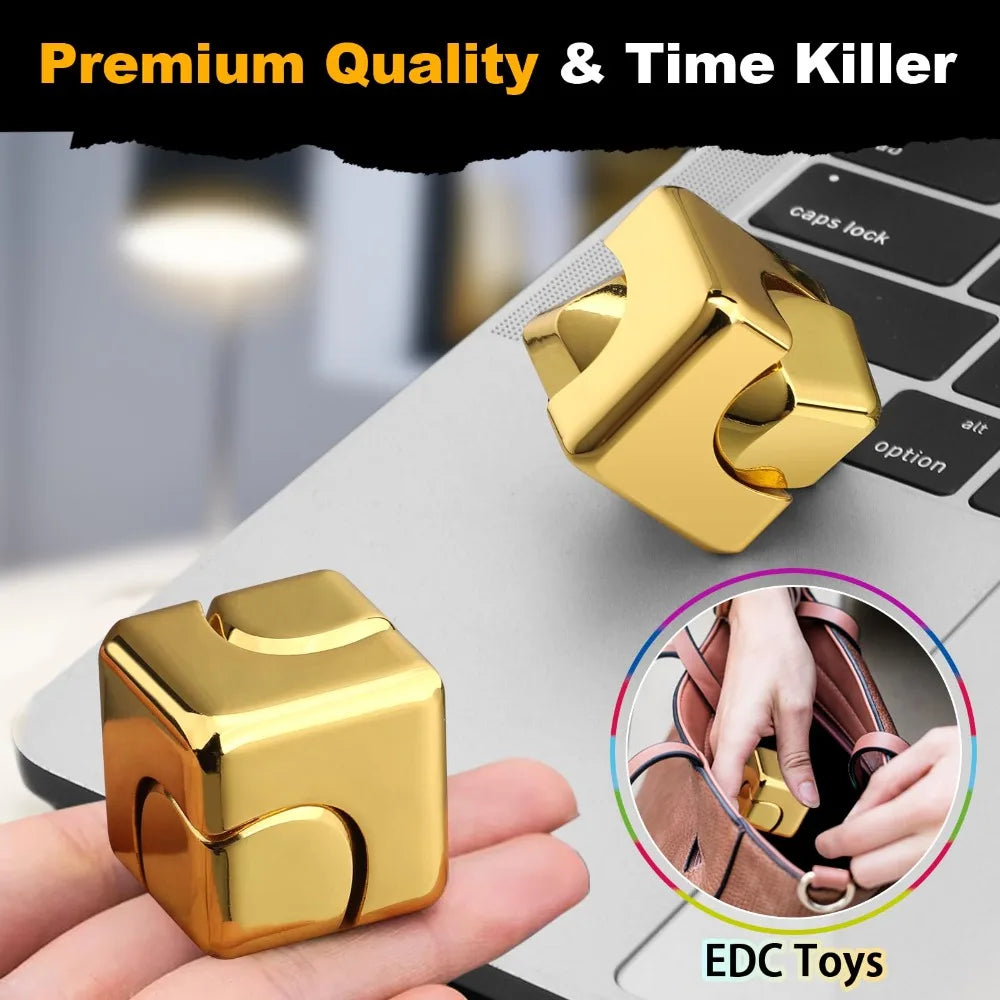 Un cube tournant en alliage d'or, jouet anti-stress, sur un ordinateur portable et dans une main.