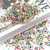 A close-up of a large, round container filled with a colorful mix of rainbow pony beads for jewelry making and craft projects
