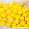 A pile of bright yellow plastic play balls for games and ball pits.
